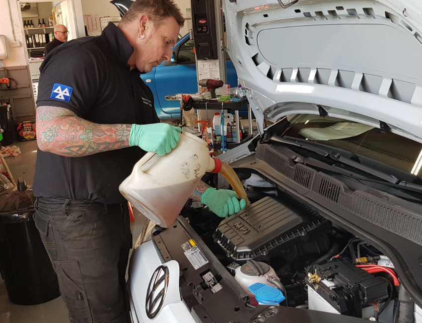 Adding new oil into a car during one of our services